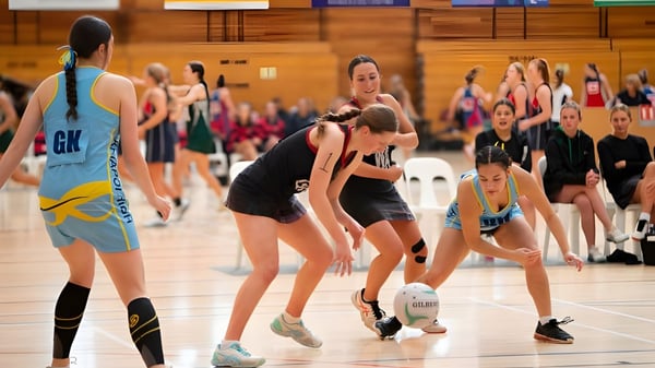 Estudiantes de la Waitaki Girls’ High School participan en una competencia en un evento deportivo en el gimnasio.