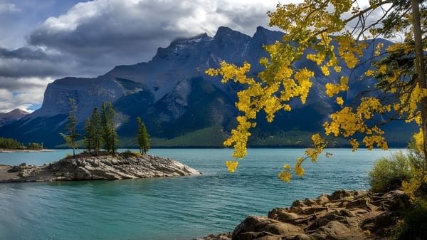 Un tranquilo lago con montañas y follaje otoñal forma el paisaje natural cerca de la Walter Murray Collegiate.