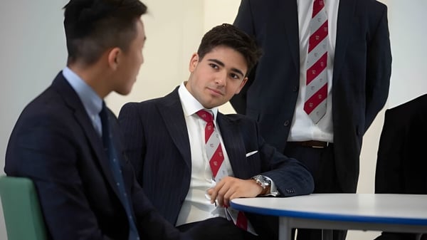 Dos hombres en traje formal mantienen una conversación profesional en una oficina en el campus de la Warwick School.