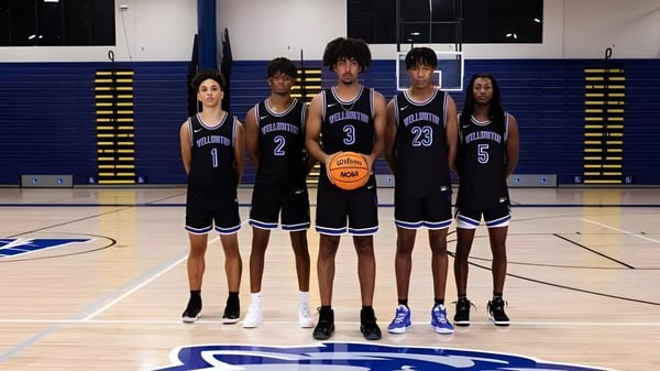 Cinco estudiantes de la Wellington High School están juntos en la cancha de baloncesto con camisetas negras.