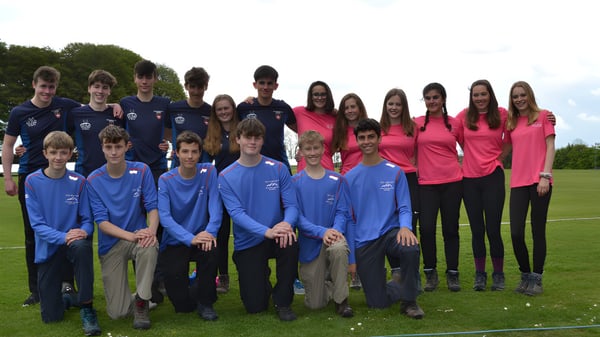 Un grupo de estudiantes de la West Buckland School está en un campo de hierba frente a unos árboles.