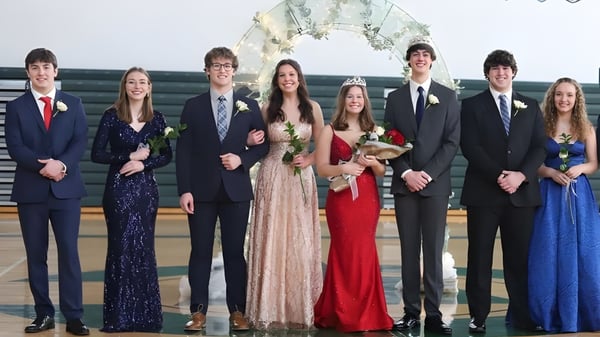 Estudiantes de la West Catholic High School en ropa formal en un evento en el auditorio.