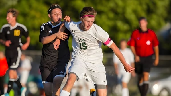 Dos alumnos de la Western Michigan Christian School juegan entre sí en el campo de fútbol.