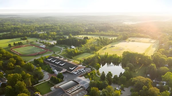 La Western Reserve Academy muestra una instalación deportiva con edificios escolares y un lago en medio de un terreno boscoso.