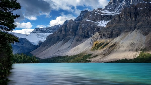 El tranquilo lago turquesa frente a montañas cubiertas de nieve cerca de la Westisle Composite High School.