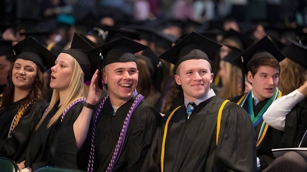 Un gran grupo de graduadas y graduados de la Westminster Secondary School en vestimenta académica durante una ceremonia de graduación.
