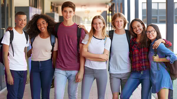 Un grupo de estudiantes está junto en el pasillo de la Westview Freedom Academy con ropa de ocio colorida.