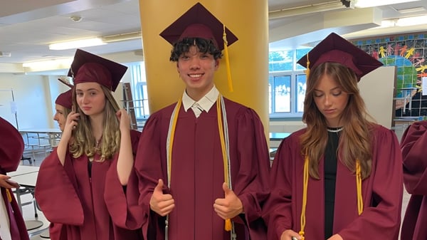 Un grupo de estudiantes de la Westwood High School está junto en togas de graduación.