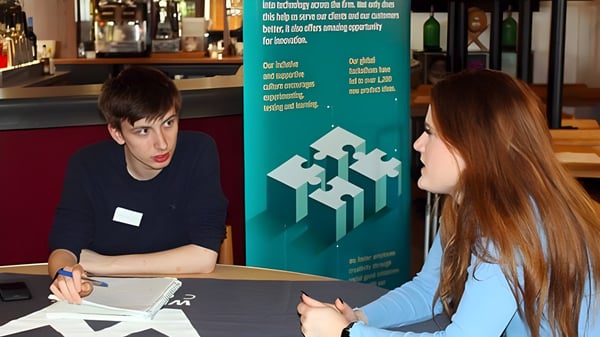 Dos personas mantienen una conversación en un café en el campus del Weymouth College.