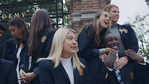 Un grupo de estudiantes de la Wilbraham & Monson Academy está junto y conversando en el campus escolar.