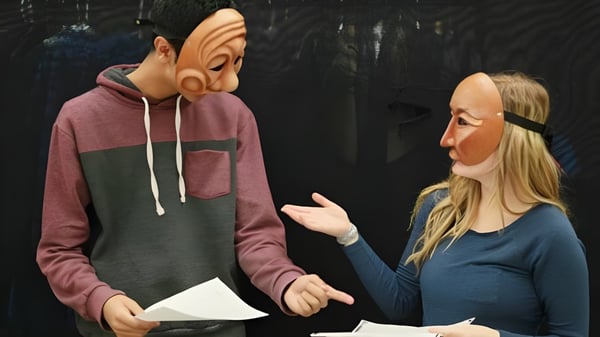 Dos estudiantes de la William Aberhart High School realizan una interacción en una habitación oscura.