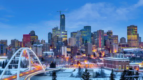 La imagen muestra una noria frente al horizonte cerca de la Willow Creek Composite High School de noche.