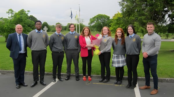 Un grupo de estudiantes de la Wilson's Hospital School está en un parque con árboles y áreas verdes.