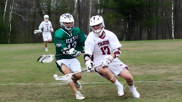 Dos jugadoras de lacrosse corren en un campo verde en el campus de la Winchendon School en Nueva York.