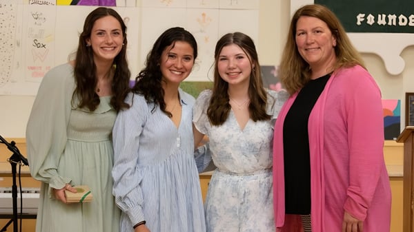 Cuatro mujeres sonríen en un aula de la Winchendon School en Massachusetts.