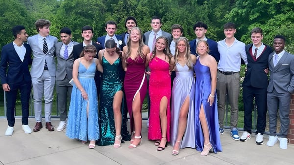 Un grupo de estudiantes de la Winston Salem Christian School está juntos en un área exterior verde.