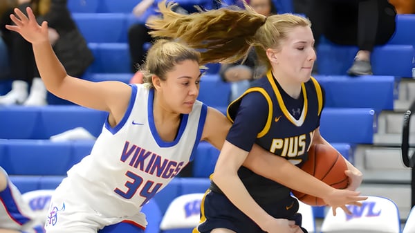 Dos jugadoras de baloncesto luchan por el balón en la cancha de la Wisconsin Lutheran High School.