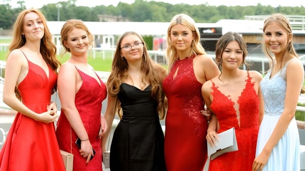 Un grupo de alumnas de la Woldingham School posan al aire libre frente a un fondo boscoso.