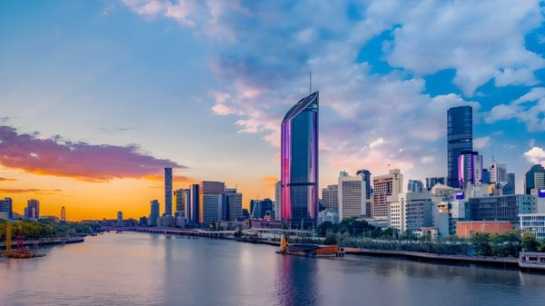 Un paisaje urbano con altos rascacielos y un río al atardecer en el campus del Woodcrest State College.