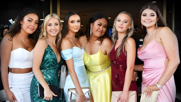 Un grupo de estudiantes del Woodcrest State College posan juntas en un evento formal.