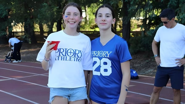 Dos alumnas de la Woodside Priory School están en la pista de atletismo en el área deportiva de la escuela.