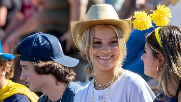 Un grupo de estudiantes de la Woodstock Academy lleva sombreros y accesorios coloridos en una fiesta.