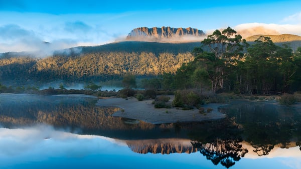 El tranquilo lago con las montañas y bosques al fondo muestra un paisaje cerca de la Woodville High School.