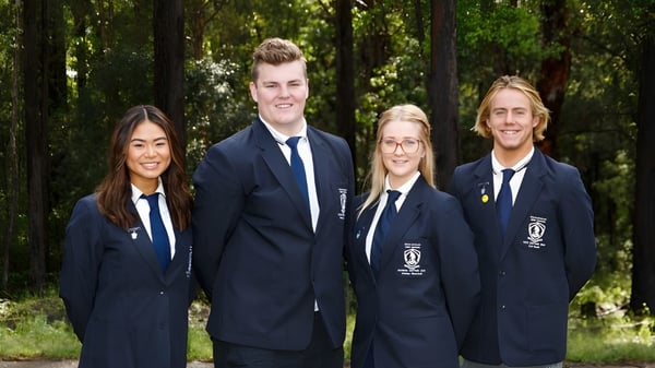 Cuatro estudiantes de la Woolgoolga High School están juntos en una zona boscosa.