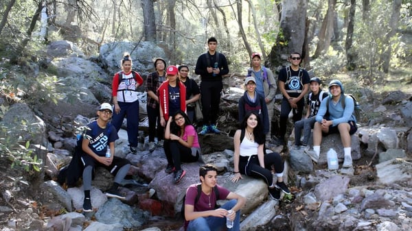 Un grupo de jóvenes está en un camino rocoso en el bosque en el terreno de Worksop College.