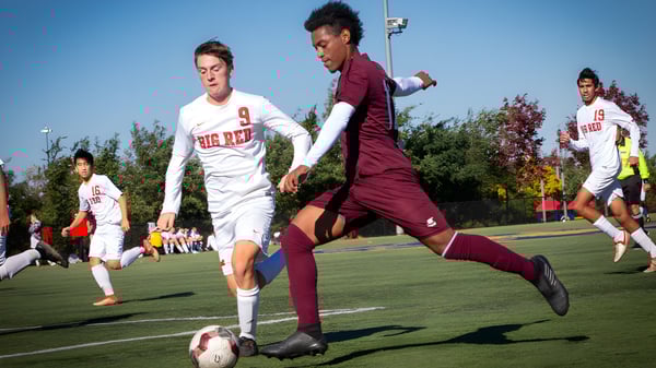 Estudiantes del Wycliffe College juegan un partido de fútbol en el campo verde.