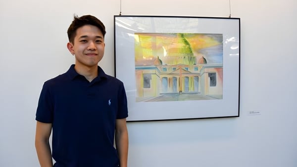 Un joven está frente a una pintura arquitectónica colorida en el campus de Wyoming Seminary College Preparatory.