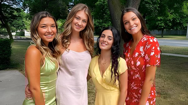 Cuatro estudiantes están juntas en un parque en el terreno del York Mills Collegiate Institute.